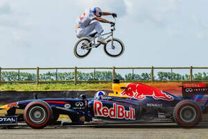 「正面衝突寸前！」BMXライダーが疾走するF1をジャンプで飛び越え!? 絶妙なタイミングすぎる